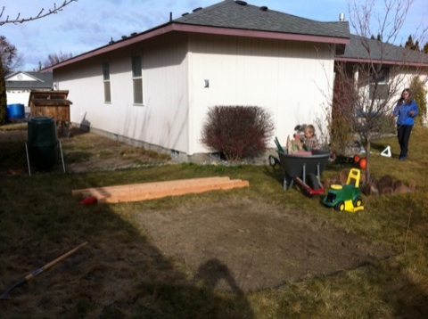 Starting to gather parts and tools around a dirt patch cut in the sod