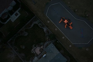 Playground and landscaping viewed from above, darkly after dusk